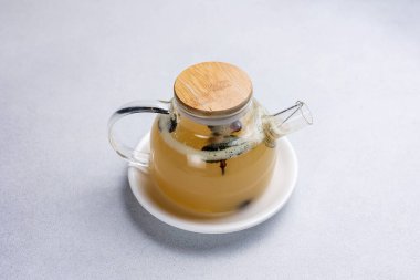 Hafif arka planda, cam çaydanlıkta yeşil çay.