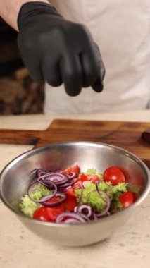 Şef bir restoranda lezzetli bir salata hazırlar.