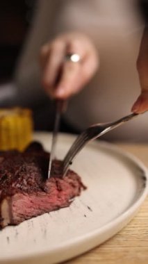 Bir kız bir restoranda et yemeği yiyor. Yakın çekimler 