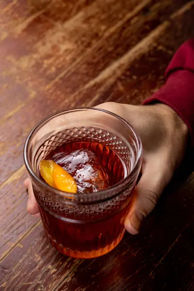 木のテーブルのガラスにオレンジと氷が付いているカクテル ロイヤリティフリーのストック写真