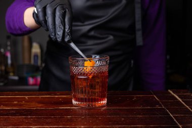 Bir barmen negroni kokteyli hazırlar. 