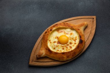 Tahtada yumurta sarısı olan Gürcü Khachapuri.