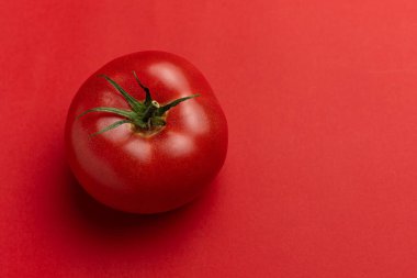 Kırmızı arka planda taze kırmızı domates. Kopyalama alanı olan üst görünüm.