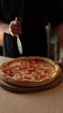 Aşçı pizzacıda pizza hazırlar.