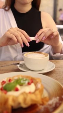 Kafede sütlü kahve içen bir kız.