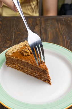 Koyu ahşap zemin üzerinde ceviz olan bir parça kek..