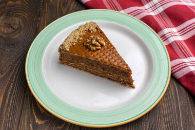 Koyu ahşap zemin üzerinde ceviz olan bir parça kek..