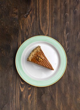 Koyu ahşap zemin üzerinde ceviz olan bir parça kek..