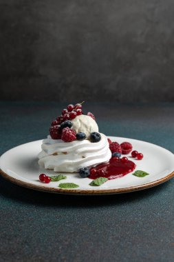 Çilekli Pavlova ve beyaz tabakta krem şanti.