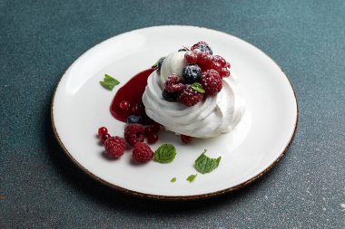 Çilekli Pavlova ve beyaz tabakta krem şanti.