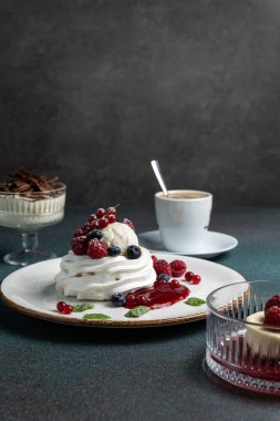 Çilekli Pavlova ve beyaz tabakta krem şanti.