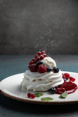 Çilekli Pavlova ve beyaz tabakta krem şanti.