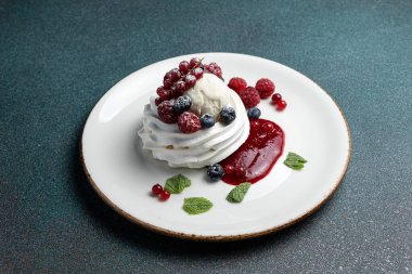 Çilekli Pavlova ve beyaz tabakta krem şanti.