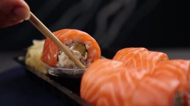 Şef lezzetli somon ruloları pişiriyor. Japon mutfağı.