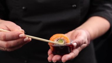 Şef lezzetli somon ruloları pişiriyor. Japon mutfağı.