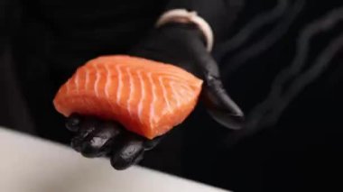 Şef lezzetli somon ruloları pişiriyor. Japon mutfağı.