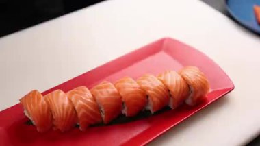 Şef lezzetli somon ruloları pişiriyor. Japon mutfağı.
