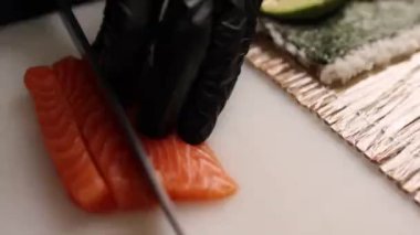 Şef lezzetli somon ruloları pişiriyor. Japon mutfağı.