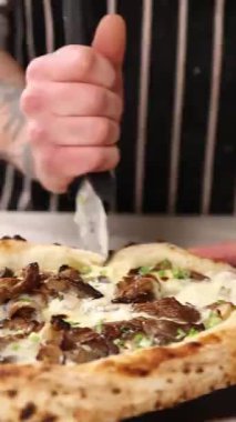 Pizzaola bir restoranda lezzetli pizza yapar.