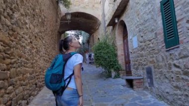 Castiglione della Pescaia İtalya, Haziran 05, 2023: Eski bir sokak arasında yürürken bir turist kız