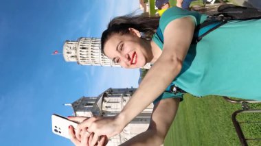 Pisa İtalya, Mayıs 06 2023: Eğik Pisa Kulesi önünde selfie çekerken gülümseyen bir bayan turist