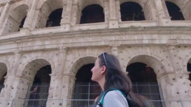 Roma, İtalya 12 Mayıs 2023: Kolezyum 'un önünde yürüyen ve Roma' yı gezerken resmini çeken genç bir kız