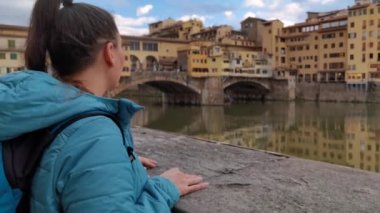 Floransa şehrini ziyaret eden bir turist kız ünlü Ponte Vecchio 'yu görmek için durur.