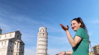 Pisa İtalya, Mayıs 06: 2023: Arkasında Eğik Pisa Kulesi ile eğlenen ve gülen genç bir kız