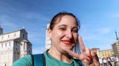 Pisa İtalya, Mayıs 06 2023: Eğik Pisa Kulesi önünde selfie çekerken gülümseyen genç bir turistin videosu