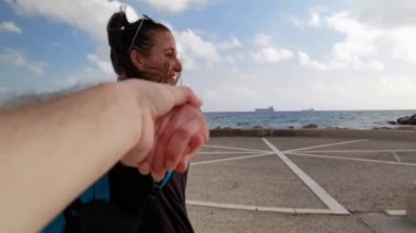 Civitavecchia 'daki rıhtımda bir çocuğun elini tutarken gülümseyen bir kız.