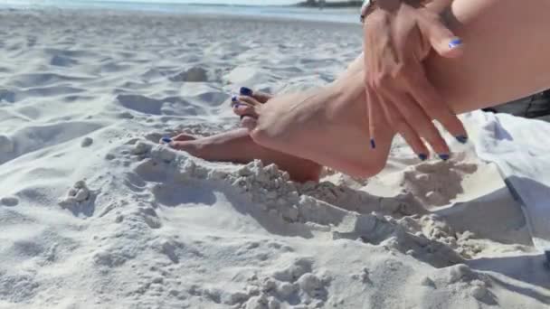 彼女の足から砂をブラッシングする少女と彼女の足が一緒に立ち往生 — ストック動画