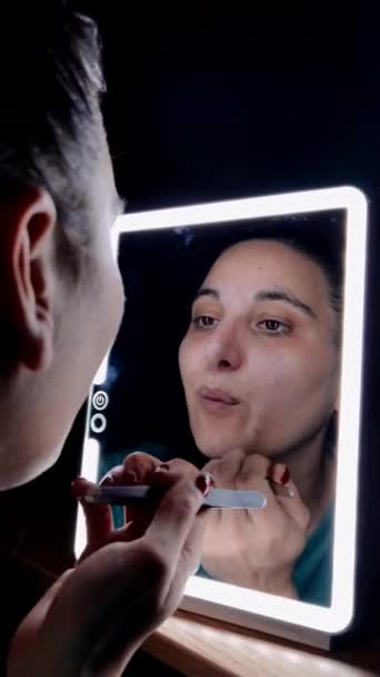 一个女孩在镜子前的特写 她用镊子把胡子从脸上拔掉 — 图库视频影像
