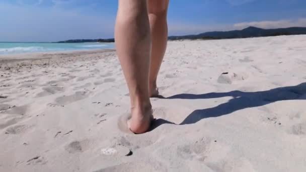 在一个白色的海滩上散步时 一个女人的腿的特写镜头 旁边是海岸 — 图库视频影像