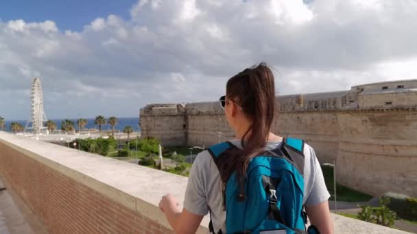 Seorang Turis Menunjuk Roda Ferris Kejauhan Dan Dinding Sekitarnya — Stok Video