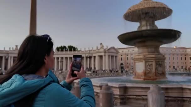 ローマのバチカン市のセントピーター広場にある噴水の写真を撮った少女のビデオ — ストック動画