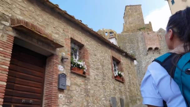 2023年6月5日 意大利帕斯卡亚卡斯蒂利昂 Castiglione Della Pescaia Italy 一位正在穿过该市历史性街道的女游客 — 图库视频影像