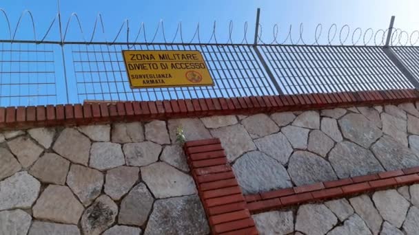 ガエタ市の有刺鉄線フェンスに装備された武装監視にアクセスできない軍事ゾーンを読むサイン — ストック動画
