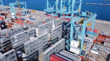 Savona İtalya, 5 Ağustos 2023: konteynırlar arasında hareket eden büyük bir kanat vincinin hava görüntüsü