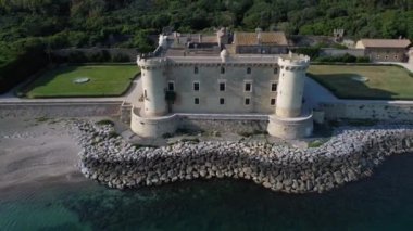 Ladispoli 'nin Odescalchi kalesinin panoramik manzaralı havadan görünüşü. Önünde deniz, arkasında bitki örtüsü var.