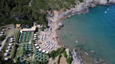 İtalya, Arjantario 'daki Porto Ercole plajının panoramik hava manzarası şemsiyeler ve şezlonglarla