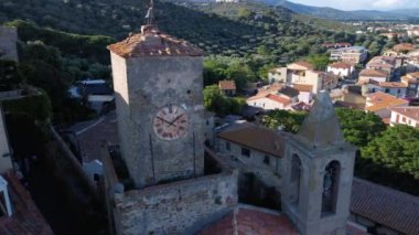 Castiglione della Pescaia 'da saati ve çan kulesi olan antik bir kulenin panoramik hava görüntüsü