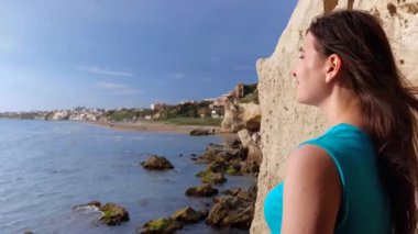 Yüzünde güneş olan kız ufukta Anzio Denizi 'ni seyrediyor.