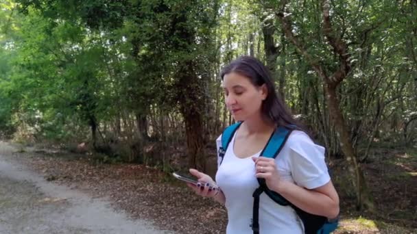ラティナ自然保護区の森で スマートフォンを使って バックパックを持った女の子 — ストック動画
