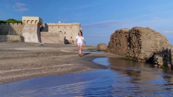 Una Ragazza Passeggiando Sulla Spiaggia Con Sullo Sfondo Castello Odescalchi — Video Stock