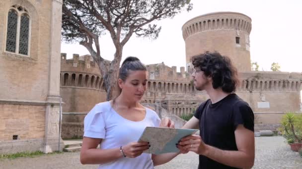 Ostia Antica Köyünün Önündeki Kalenin Coğrafi Haritasına Bakan Iki Turist — Stok video