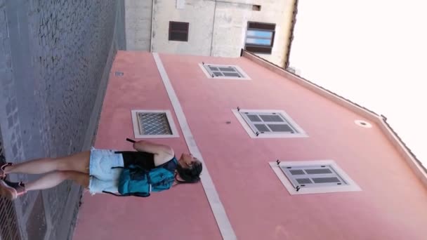 位于蒙塔尔托迪厅市中心的一座房子中 一个背着背包的女游客的垂直录像 — 图库视频影像