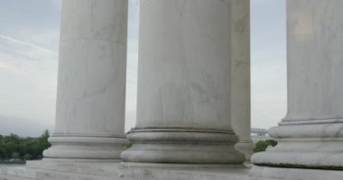 Washington Anıtı bulutlu bir günde Jefferson Anıtı 'nın sütunlarının yanında sergileniyor. Çekim Yüksek Kaliteli 4K görüntü.