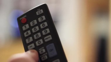 Uzaktan kumandalı bir adam Bokeh yumuşak odaklı televizyon izliyor..