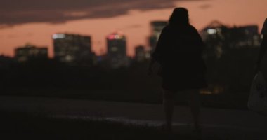 Tourists walk in front of Rossyln Virginia at Night Silhouettes in Washington DC on a beautiful summer night. High quality 4k Footage 
