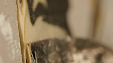 Soyut bir sanatçı musluk bıçağıyla tuvale siyaha boyar. Yakın plan çekim. Yüksek kalite 4k görüntü. 